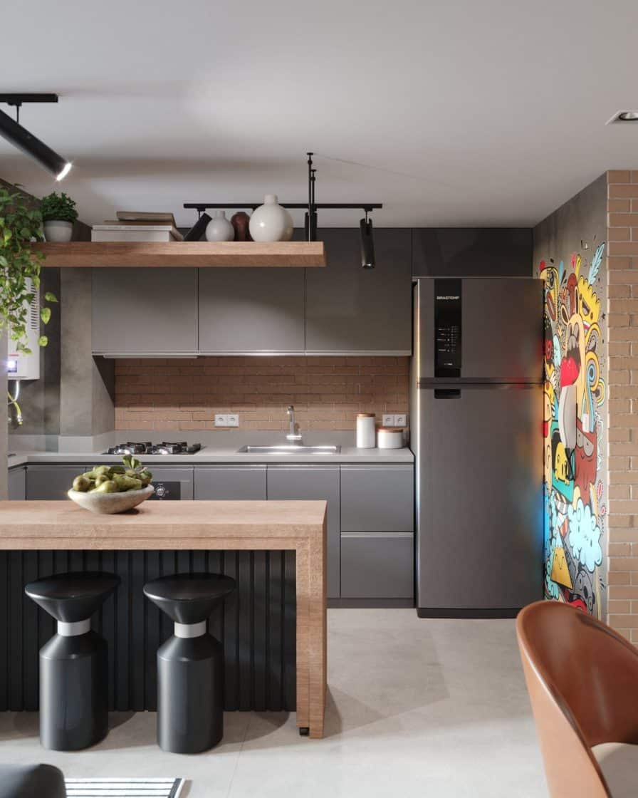 Cozinha estilo industrial, com armários em cinza, piso de porcelanato que reproduz cimento queimado e ilha em madeira.