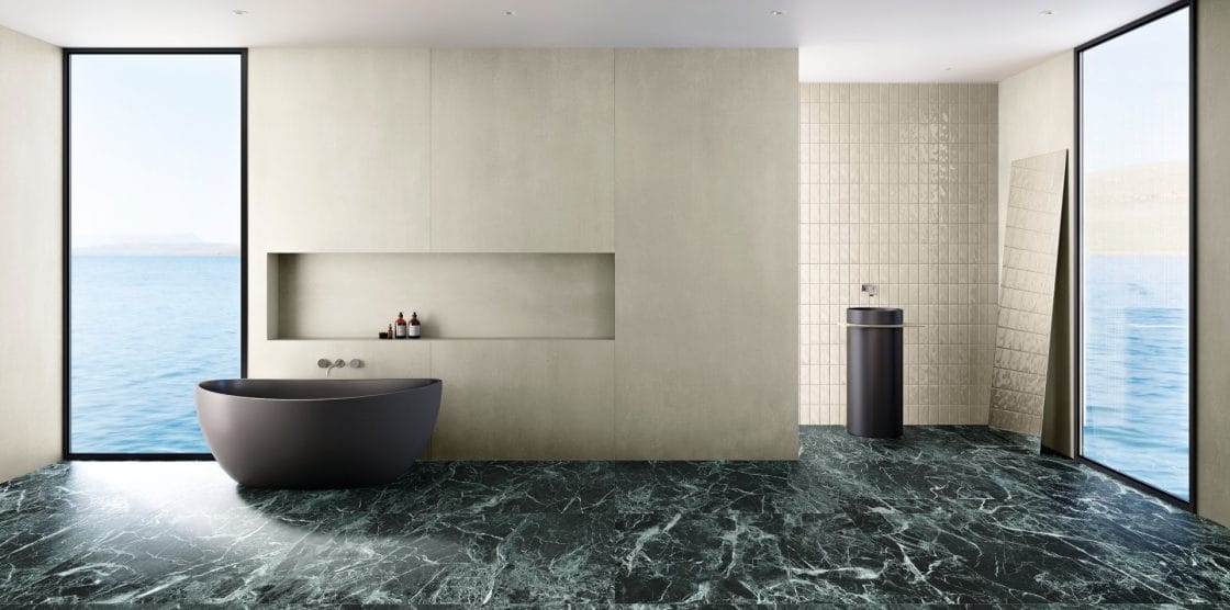 Banheiro amplo, onde o piso de mármore verde se destaca.