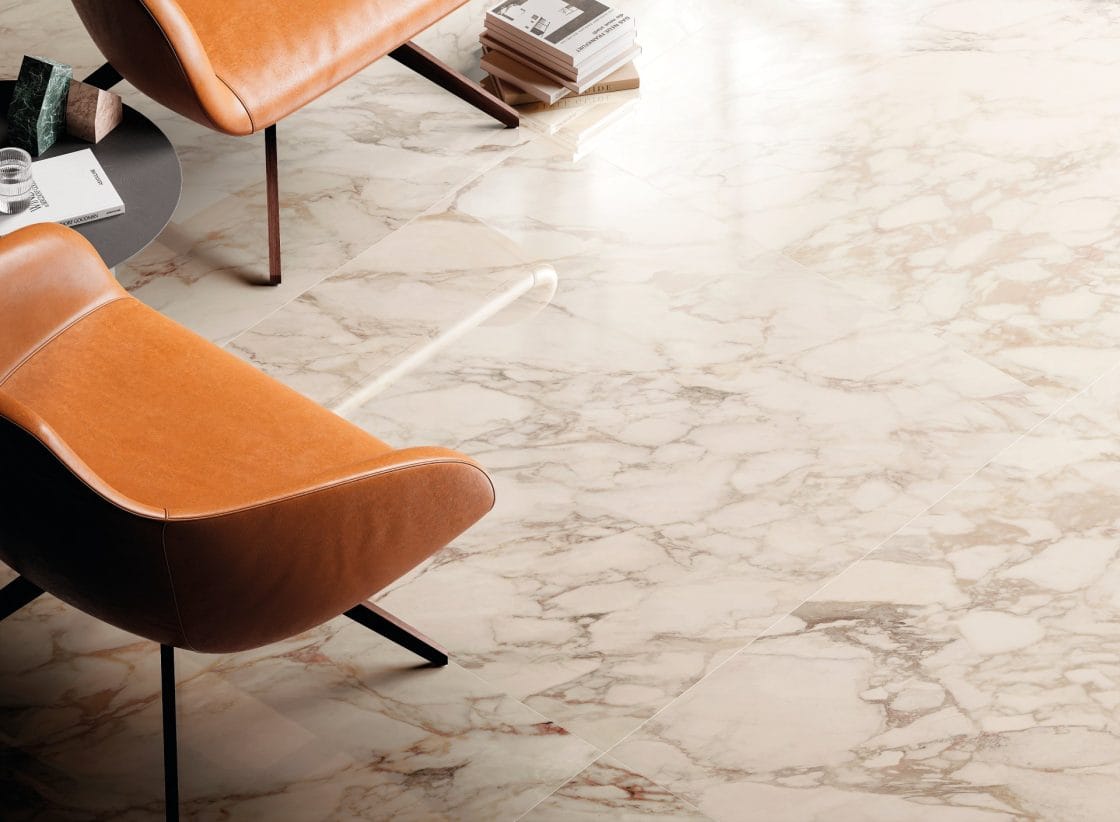 Detalhe de ambiente, com o piso em destaque. Há também cadeiras de couro.