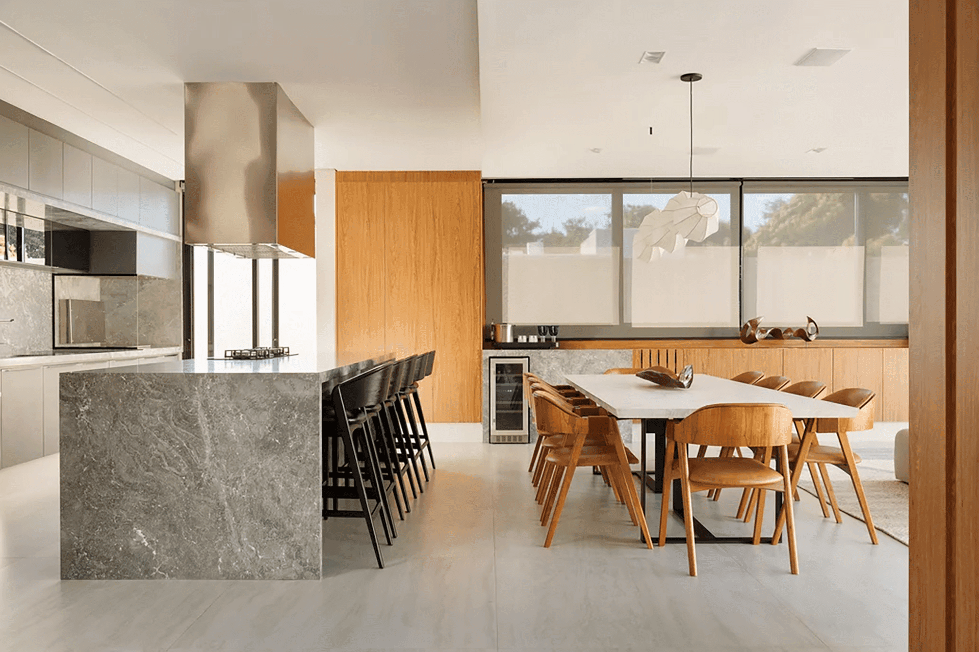 Cozinha gourmet ampla e em tons neutros, com destaque para as pedras e a madeira.