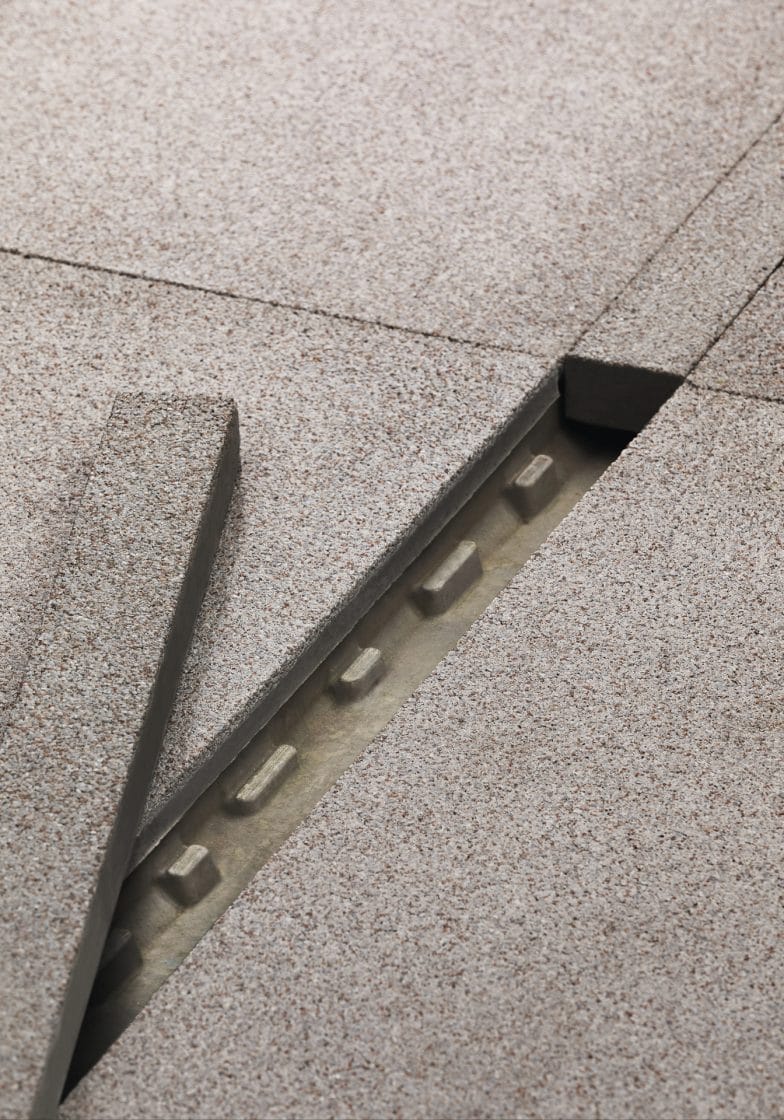 Imagem mostra ralo canal, que fica oculto sob o revestimento. Ralo está aberto, com a tampa à esquerda.