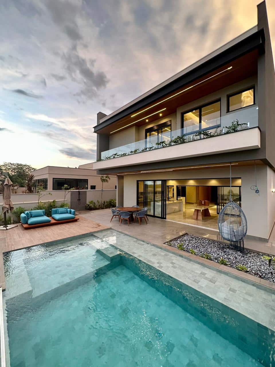 Área externa com piscina atrás de uma casa de dois andares moderna