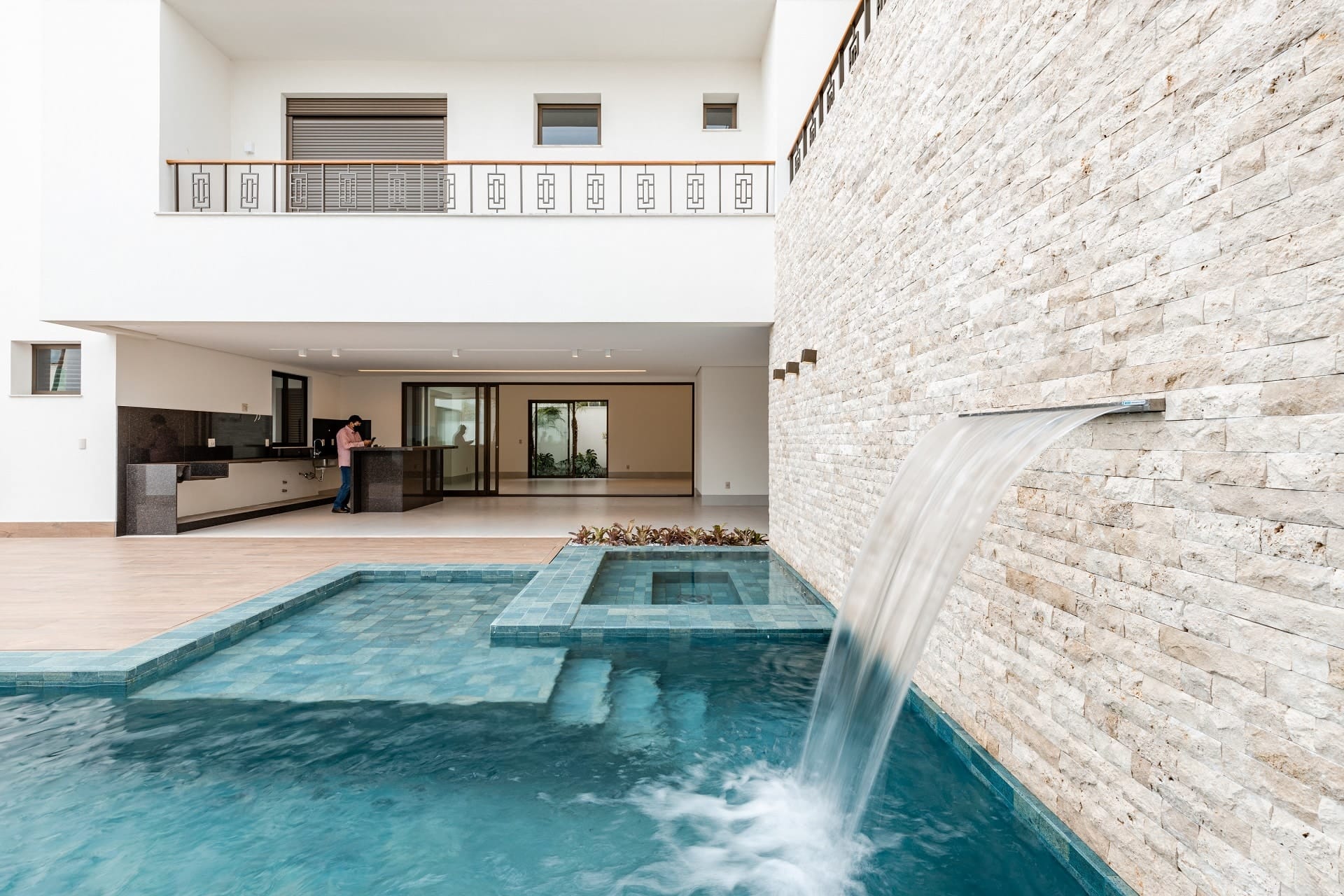 Piscina encostada em muro na parte de trás de uma casa