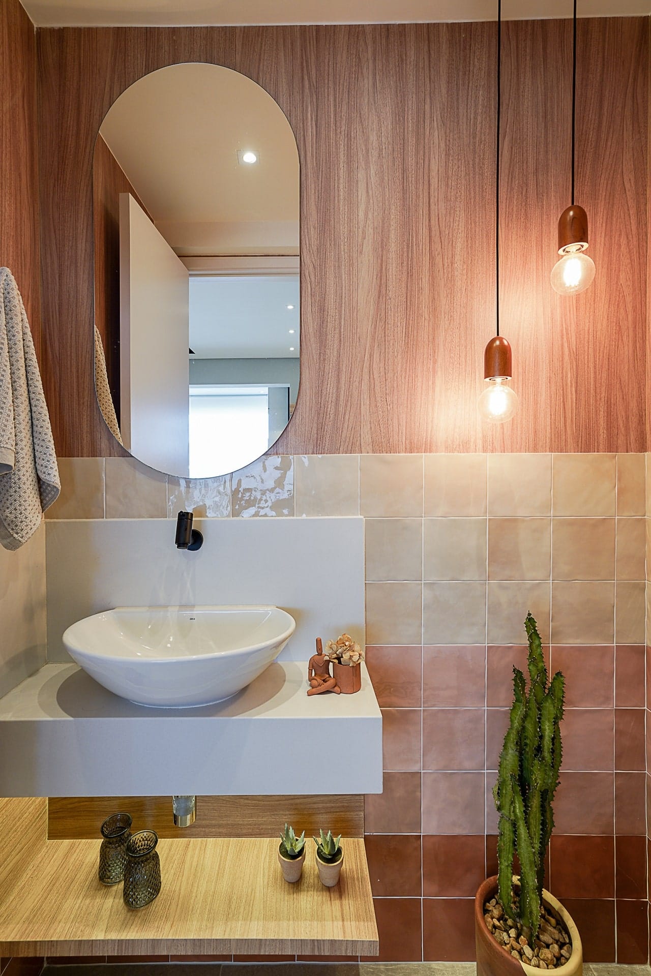 Lavabo com revestimento em degradê rosado na parede atrás da cuba