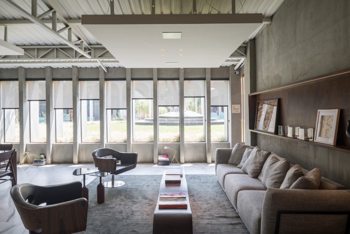 Sala de estar ampla com decoração industrial e iluminada.