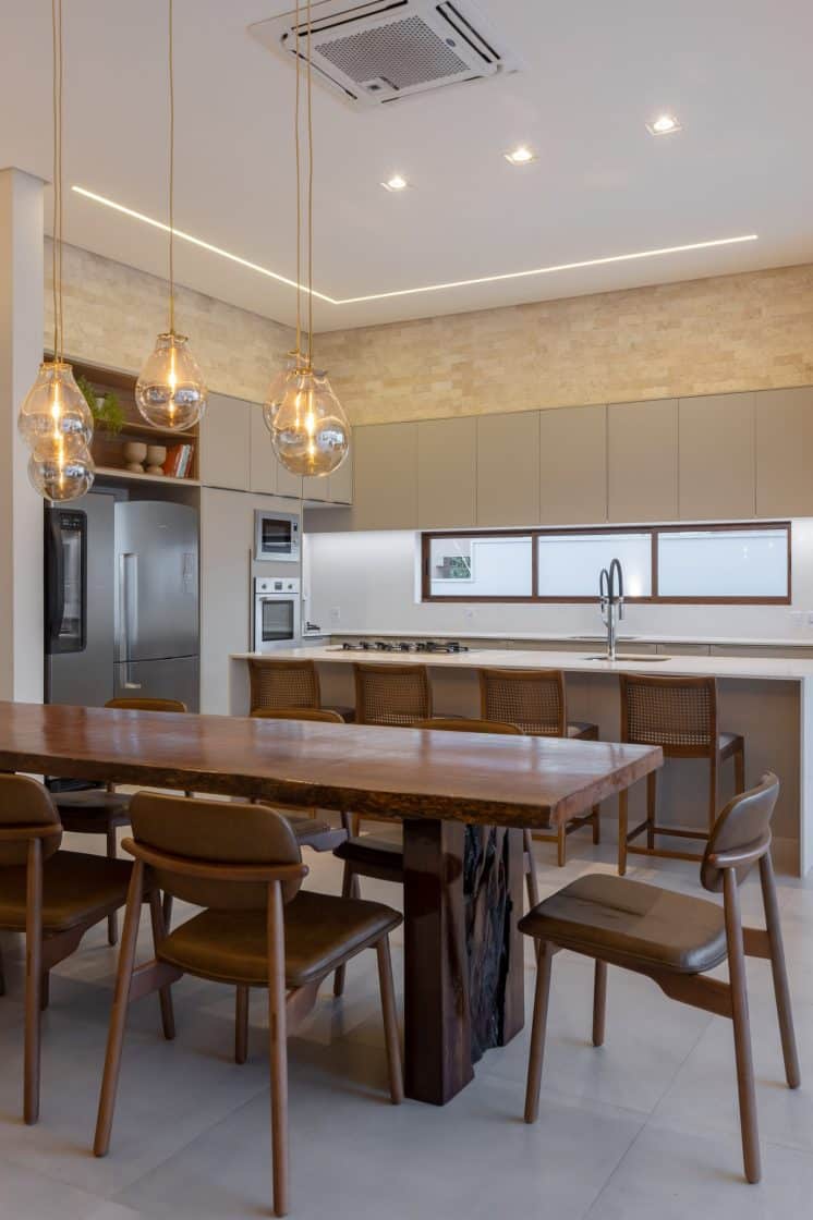 Cozinha minimalista tem mesa de jantar de forma orgânica nos pés, que ganham destaque (Projeto: Fernanda Triches)