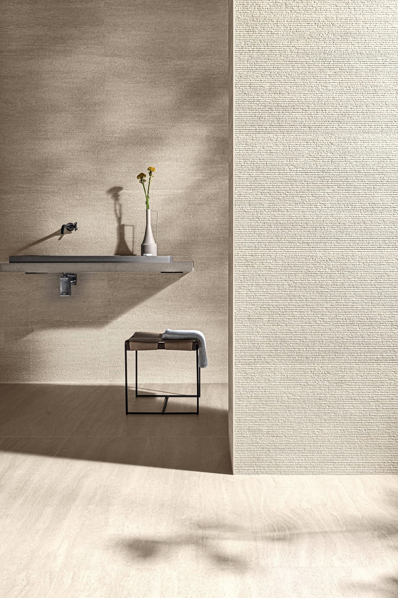 Detalhe de banheiro amplo com porcelanato que reproduz travertino