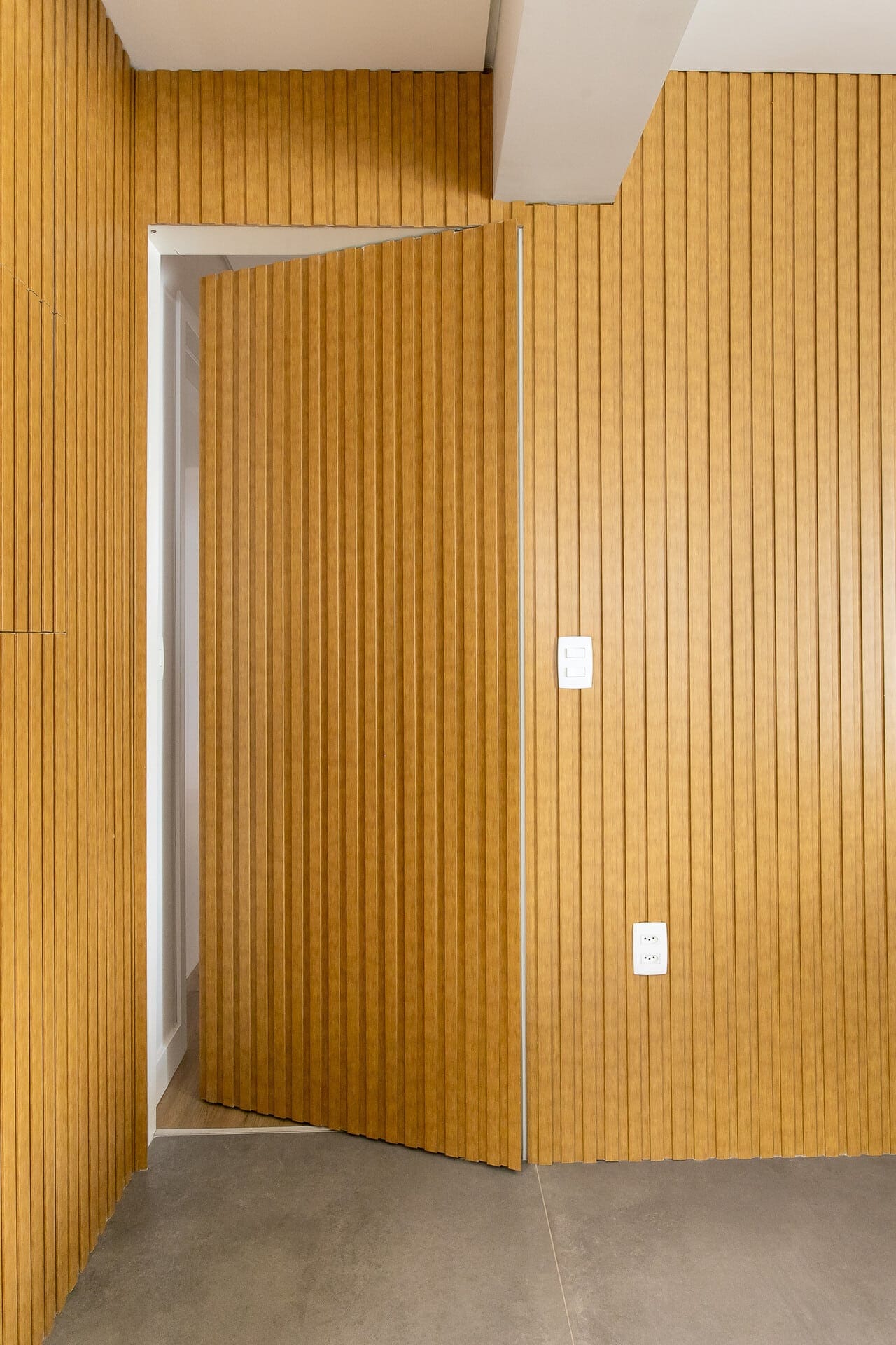 Disfarce a entrada para a área íntima com uma porta oculta: fica elegante e discreto (Projeto: Brenda Amaral Arquitetura e Interiores).