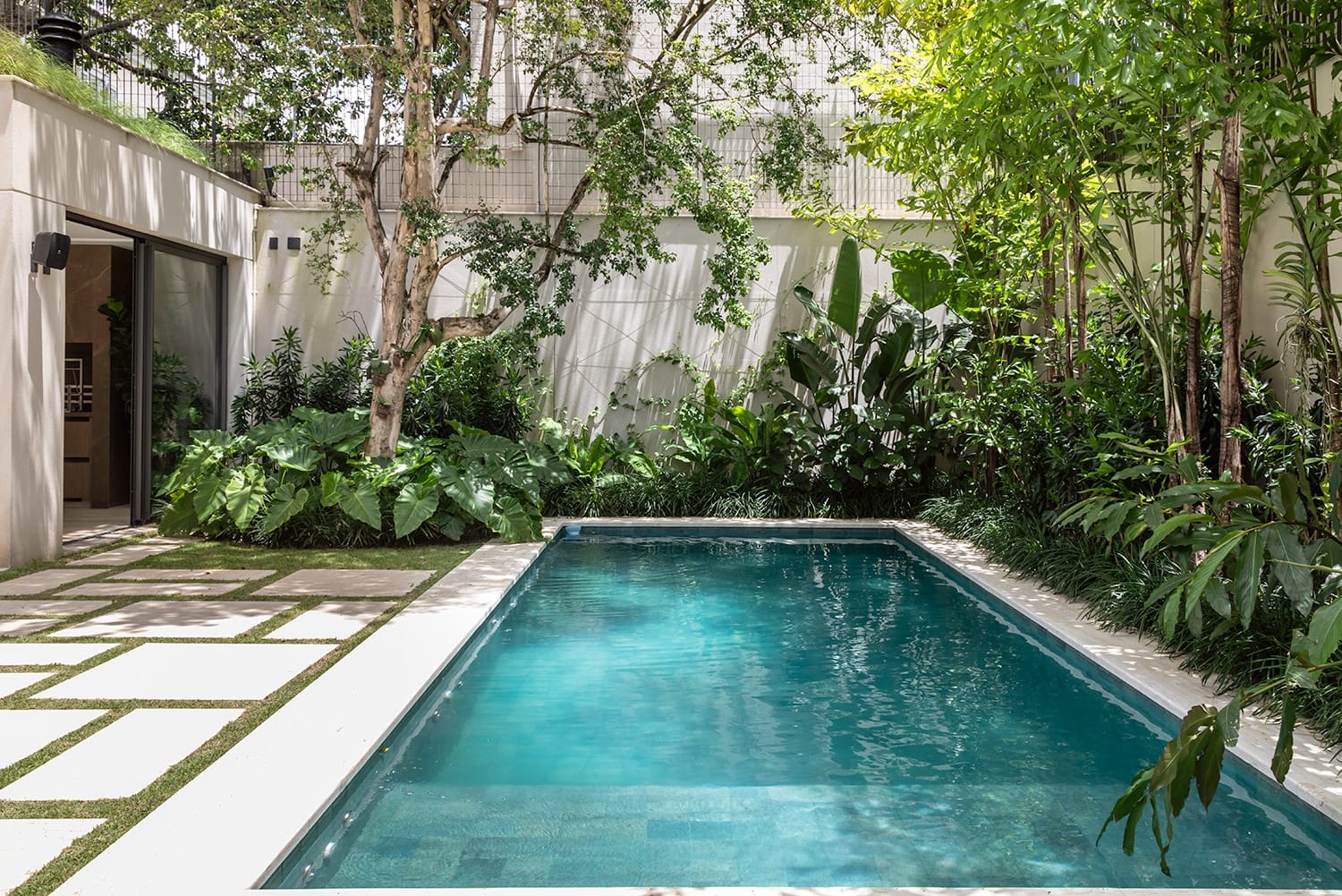 Um Jardim com piscina garante, além de uma bela vista, o contato direto com a natureza durante os momentos de lazer e relaxamento em família. (Projeto: Giselle Macedo & Patrícia Covolo)
