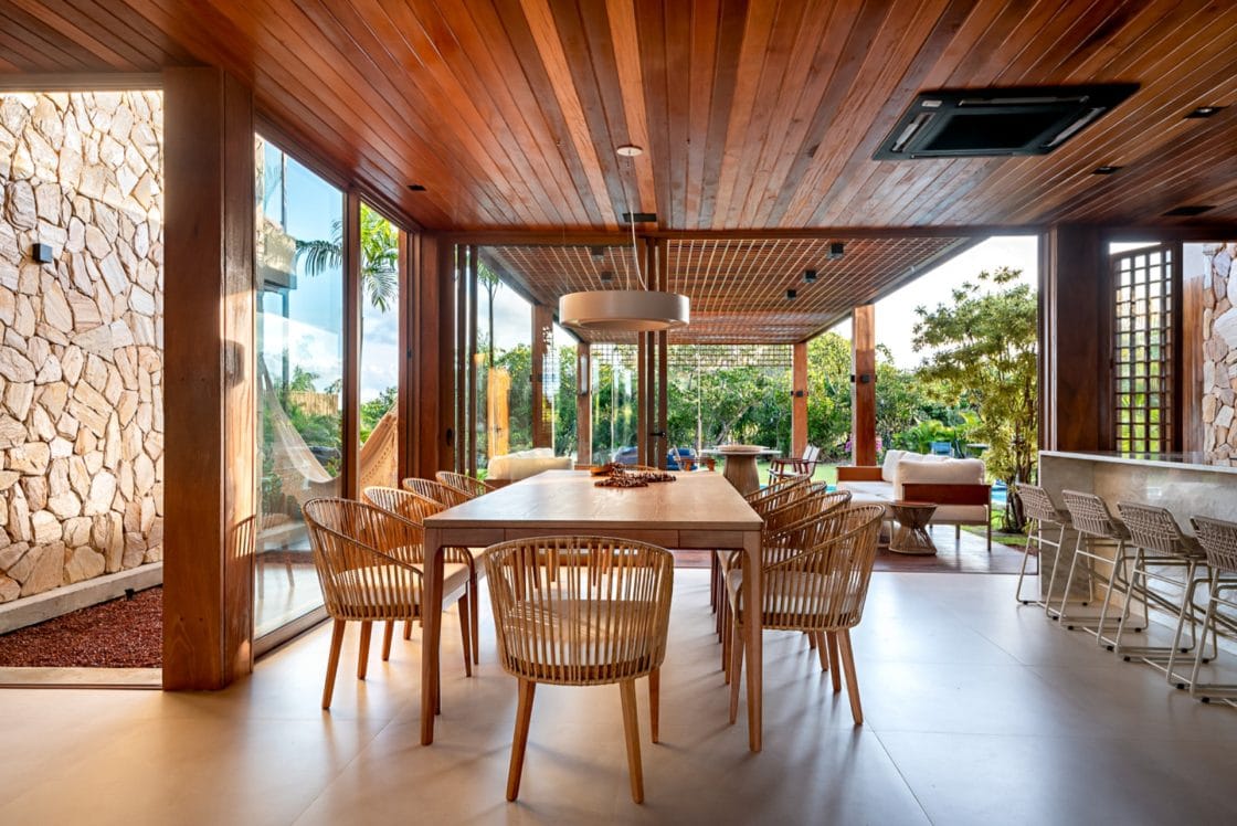 Nesta casa de praia, a madeira está presente tanto na fachada, quanto no interior, conectando a decoração dos ambientes. (Projeto: Milcent Arquitetura)
