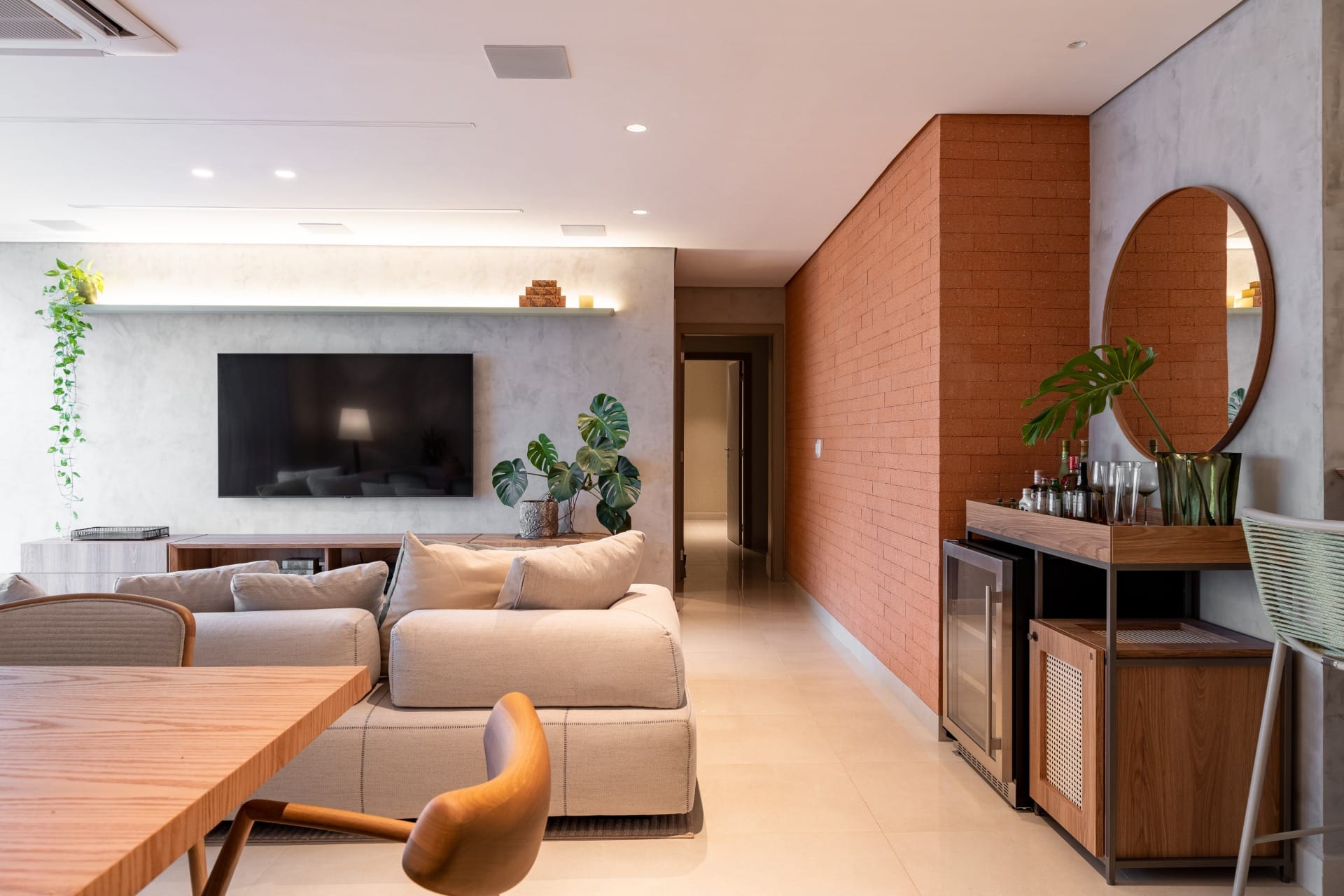 Sala de estar projetada pelo arquiteto Alexandre Marques tem variedade de textura em revestimentos e estofados (Projeto: Alexandre Marques)