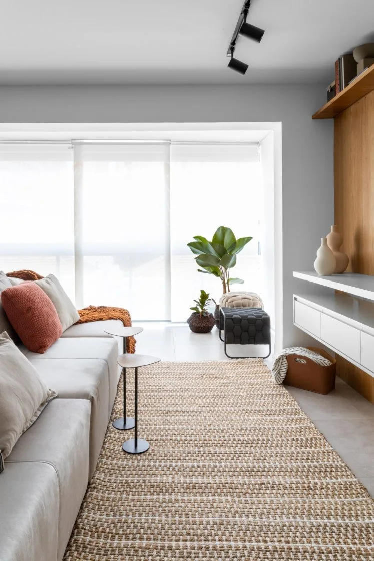 A banqueta trançada com tecido ortogonal garante design contemporâneo para a sala de estar (Projeto: Lívia Boechat Corrêa)