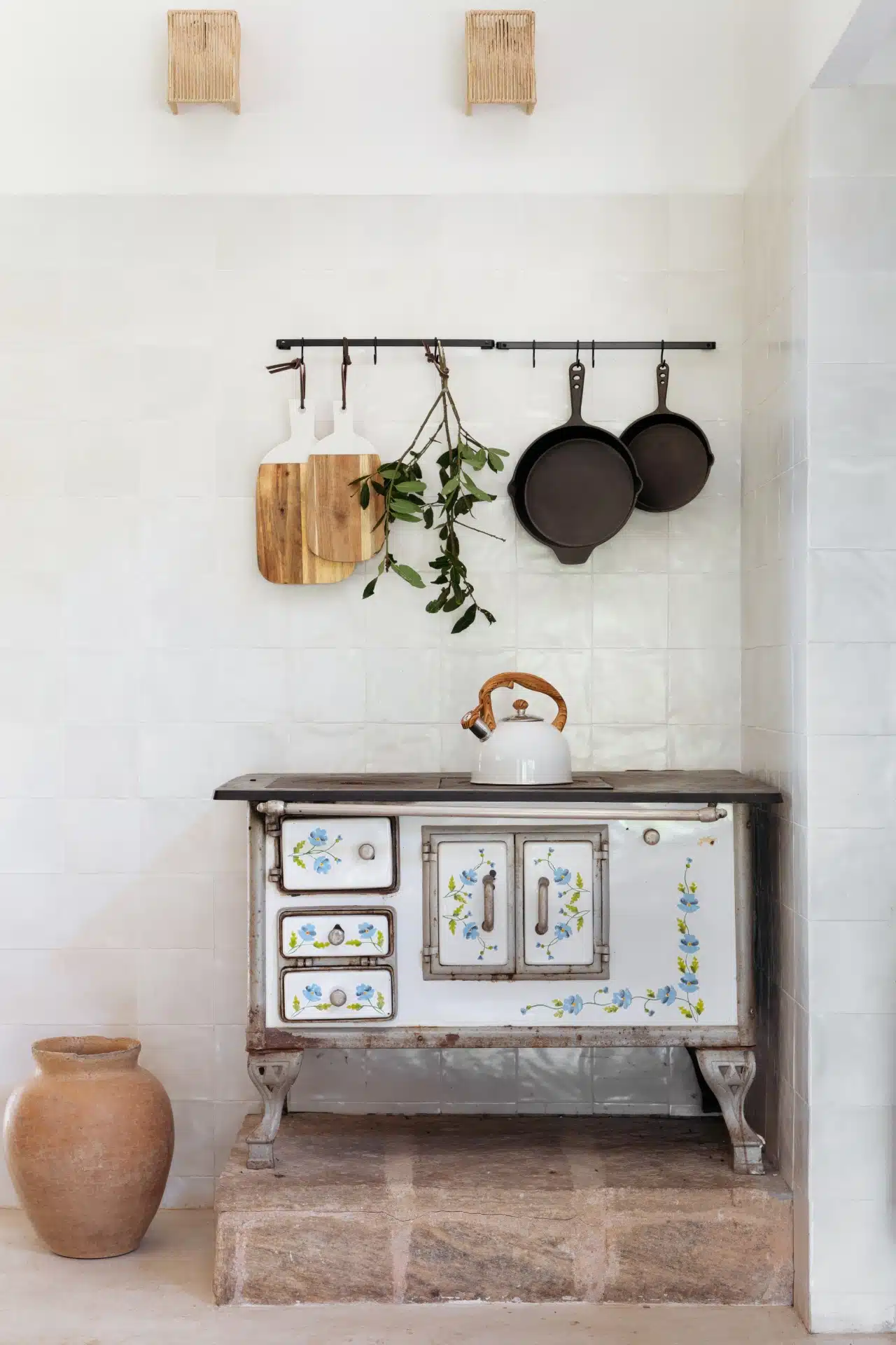 Fogão à lenha retrô com objetos de cozinha rústicos ao redor.